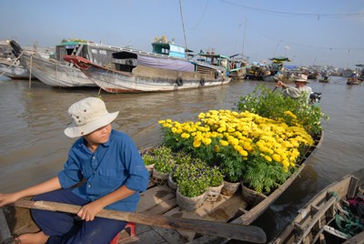 Cậu bé này đang ngồi chờ khách mua hoa.